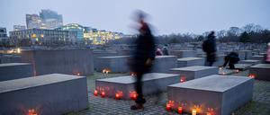 26.01.2023, Berlin: Kerzen stehen am Vorabend des Internationalen Tags des Gedenkens an die Opfer des Holocaust zwischen den Stelen des Denkmals für die ermordeten Juden Europas. (Bewegungsunschärfe durch lange Belichtungszeit) Foto: Christoph Soeder/dpa +++ dpa-Bildfunk +++