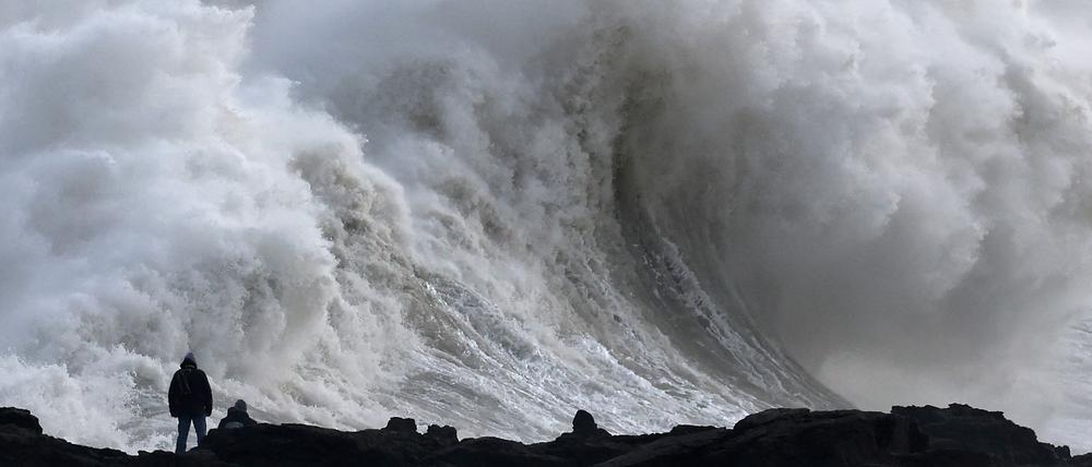 Menschen beobachten große Wellen, als der Sturm Éowyn in Porthcawl, Wales, Großbritannien, ankommt.