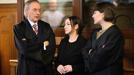 Dilek Kalayci (M, SPD) unterhält sich mit ihren Rechtsanwälten, Robert Unger und Sophia Zabel, vor Prozessbeginn im Gerichtssaal am Kriminalgericht Moabit. 