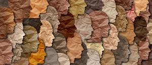 Aus Papier ausgeschnittene Gesichter in verschiedenen Farben.