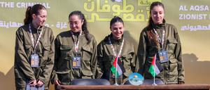 Four Israeli hostages stand on a stage before Hamas fighters hand them over to a team from the Red Cross in Gaza City on January 25, 2025. (Photo by John Wessels / AFP)