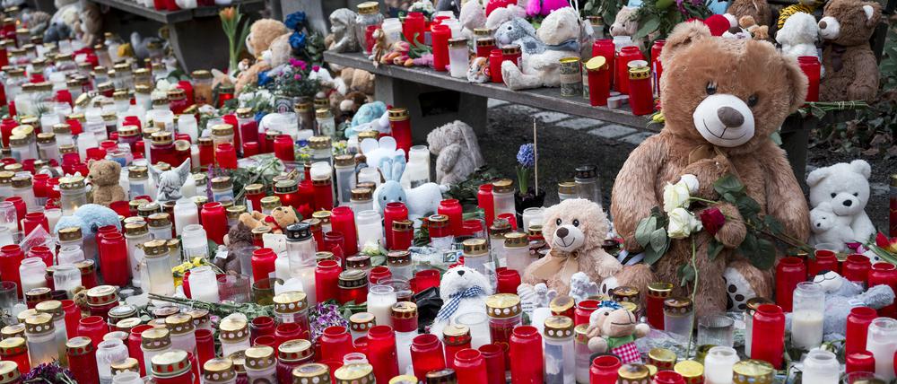 Zahlreiche Kerzen und Blumen liegen zum Gedenken an die Opfer des tödlichen Messerangriffs im Park Schöntal in Aschaffenburg am Boden.