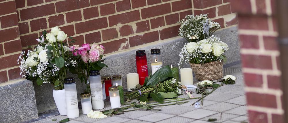 Blumen und Kerzen stehen vor dem Eingang eines Hauses nach einem Gewaltverbrechen.