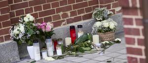 Blumen und Kerzen stehen vor dem Eingang eines Hauses nach einem Gewaltverbrechen. 