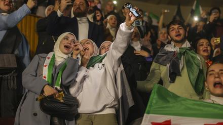 Syrer singen und schwenken Flaggen der Syrischen Opposition während eines Konzerts des kürzlich zurückgekehrten „revolutionären“ Sängers Wasfi Maasrani in Damaskus. 