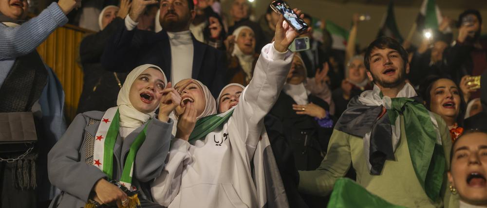 Syrer singen und schwenken Flaggen der Syrischen Opposition während eines Konzerts des kürzlich zurückgekehrten „revolutionären“ Sängers Wasfi Maasrani in Damaskus.