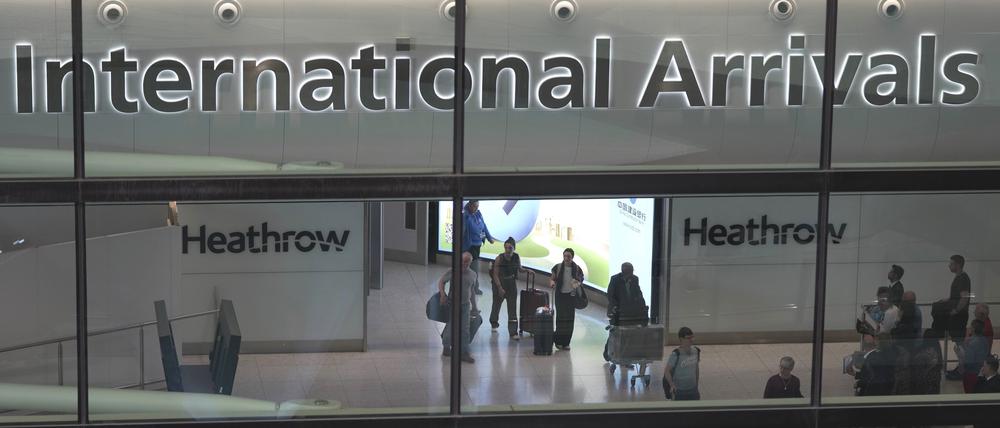 Passagiere kommen am International Arrivals auf dem Flughafen Heathrow in London an. 