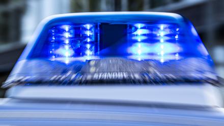 Das Blaulicht an einem Polizeiwagen ist eingeschaltet.
