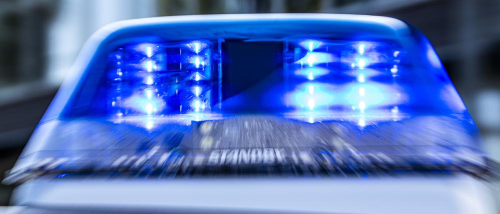Das Blaulicht an einem Polizeiwagen ist eingeschaltet.