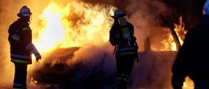 Feuerwehrmänner der Berliner Feuerwehr löschen ein brennendes Auto. (Symbolbild)
