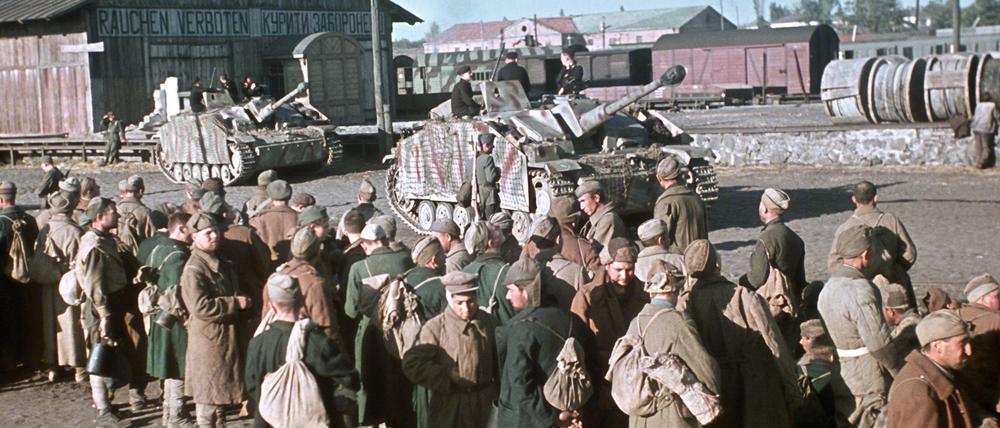 Russische Kriegsgefangene in der Ukraine, bewacht von deutschen Panzern, warten auf ihren Abtransport im Jahre 1943. 