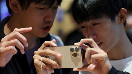 Zwei Kunden mit dem neuen iPhone 16 im Apple-Shop in Peking.