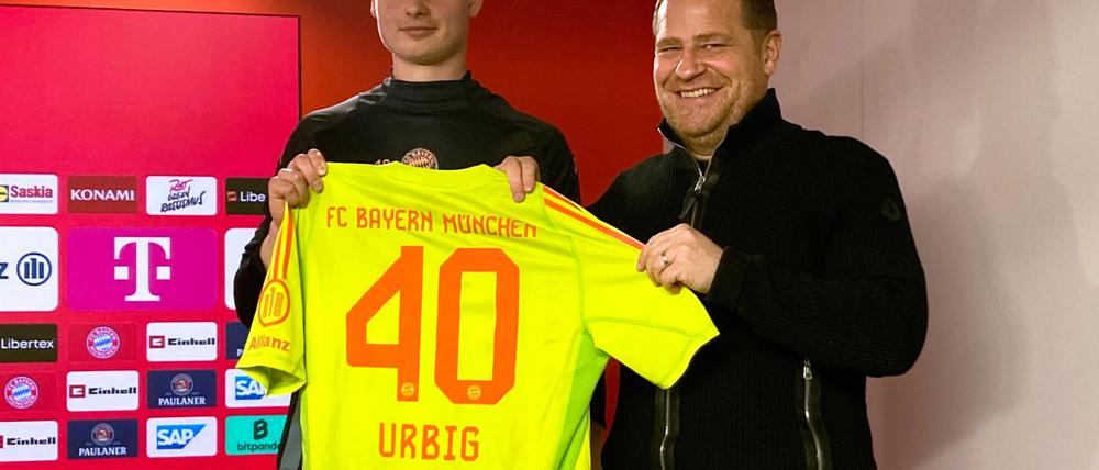 Jonas Urbig (l) präsentiert das Bayern-Trikot mit der Nummer 40 bei seiner Vorstellung mit Sportvorstand Max Eberl.