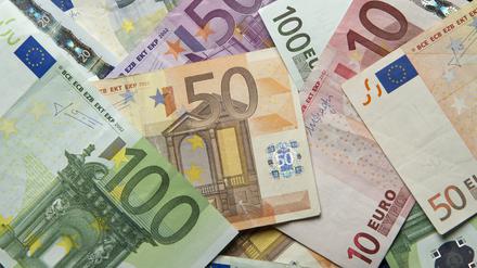 Zahlreiche Euro-Banknoten liegen auf einem Tisch.