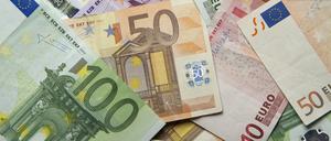 Zahlreiche Euro-Banknoten liegen auf einem Tisch.
