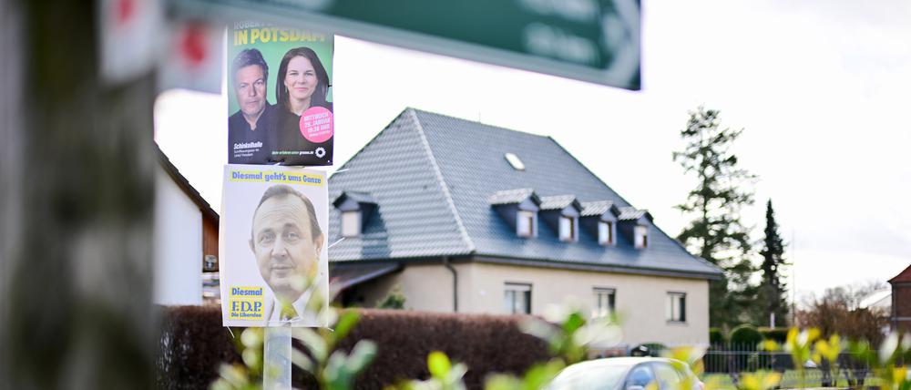 31.01.2025, Brandenburg, Stahnsdorf: Ein Wahlplakat der FDP zur Bundestagswahl 1980 mit dem Gesicht des damaligen Außenministers und Vizekanzlers Hans-Dietrich Genscher und dem Slogan «Diesmal geht’s ums Ganze» hängt an einer Laterne unter einem Plakat der Grünen.
