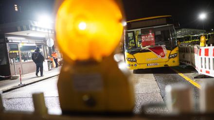 Ein Bus mit der Aufschrift „Warnstreik“ steht in der Einfahrt eines Betriebshofs der BVG. 