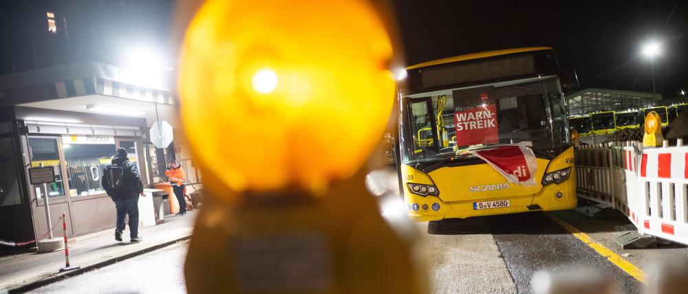 Ein Bus mit der Aufschrift „Warnstreik“ steht in der Einfahrt eines Betriebshofs der BVG. 