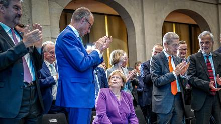 Bei ihrem 70. Geburtstag nahm Angela Merkel (Mitte) den Applaus von Friedrich Merz sichtbar wenig begeistert entgegen.
