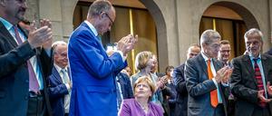 Bei ihrem 70. Geburtstag nahm Angela Merkel (Mitte) den Applaus von Friedrich Merz sichtbar wenig begeistert entgegen.