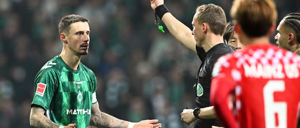 Martin Petersen zeigt Werders Marco Friedl Gelb-Rot.