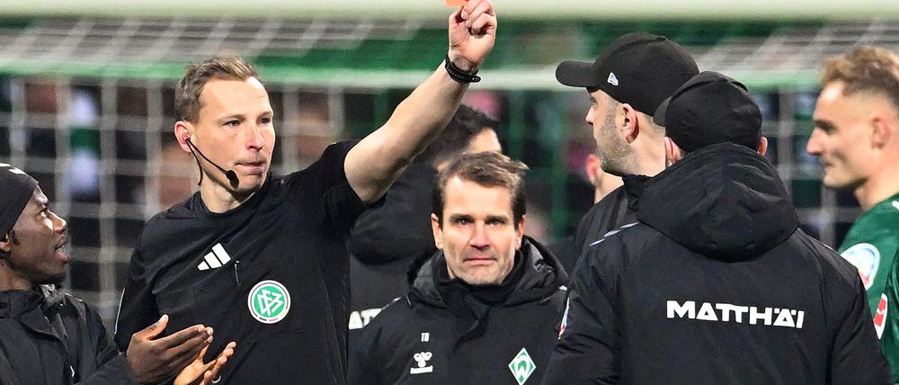 Schiedsrichter Martin Petersen zeigt Werder-Trainer Ole Werner die Rote Karte. 
