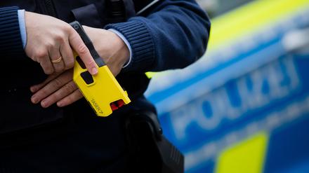 Ein Polizeibeamter demonstriert ein Distanz-Elektroimpulsgerät (DEIG oder auch Taser) im Trainingsmodus ohne scharfe Munition. Das Gerät sendet nach Abschuss zweier Elektroden Stromimpulse ab. (Symbolbild)