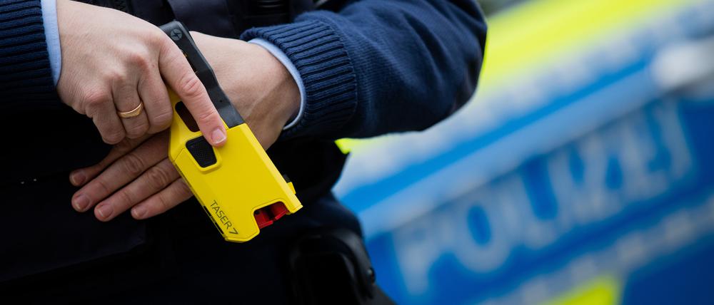 Ein Polizeibeamter demonstriert ein Distanz-Elektroimpulsgerät (DEIG oder auch Taser) im Trainingsmodus ohne scharfe Munition. Das Gerät sendet nach Abschuss zweier Elektroden Stromimpulse ab. (Symbolbild)