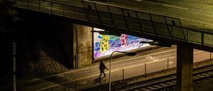 Stockholm, Sweden Oct 19, 2023 A person walks alone through a dark passage at night in the rain.