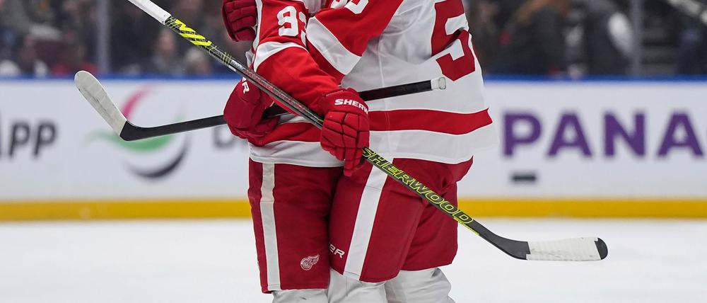 Moritz Seider (re.) feiert mit Alex DeBrincat den Siegtreffer in Vancouver - den sechsten Sieg in Serie mit den Detroit Red Wings.