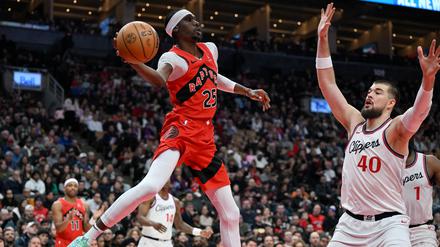 Feb 2, 2025; Toronto, Ontario, CAN;  Toronto Raptors forward Chris Boucher (25) passes the ball over Los Angeles Clippers center Ivica Zubac (40) in the first half at Scotiabank Arena. 