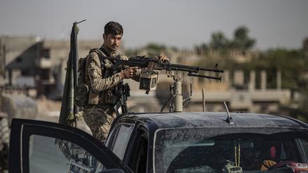 Ein von den USA unterstützter Kämpfer der Syrischen Demokratischen Kräfte (SDF) steht auf einem gepanzerten Fahrzeug in Ostsyrien. Die Kurdenmilizen kämpfen im Raum Manbidsch gegen Türkei-nahe Milizen.