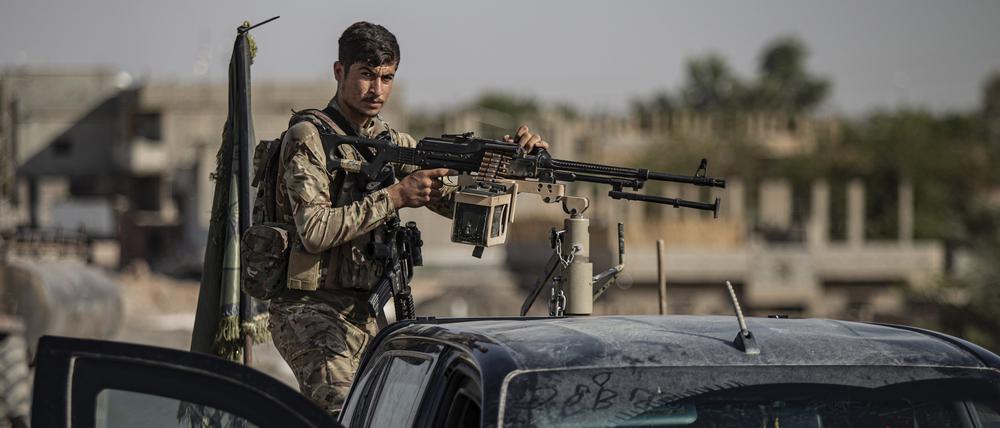 Ein von den USA unterstützter Kämpfer der Syrischen Demokratischen Kräfte (SDF) steht auf einem gepanzerten Fahrzeug in Ostsyrien. Die Kurdenmilizen kämpfen im Raum Manbidsch gegen Türkei-nahe Milizen.