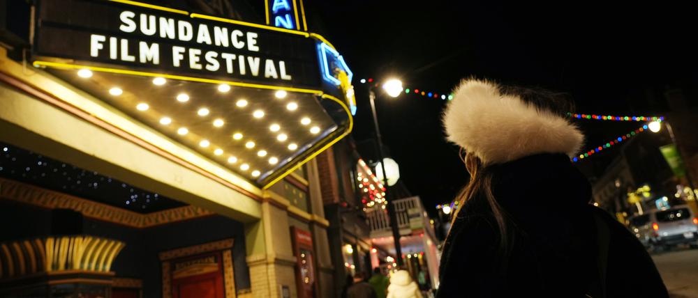 Eine Passantin blickt vor dem Beginn des Sundance Film Festivals 2025 auf das Festzelt des Egyptian Theaters.