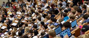 Studierende im Hörsaal. Wegen hoher Einsparungen bis 2027 in der Wissenschaft, müssen die Berliner Hochschulen voraussichtlich ihr Studienangebot herunterschrauben.