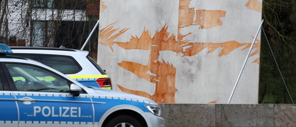 Ein Polizeiauto steht vor einem zerstörten Wahlplakat. (Archivbild)