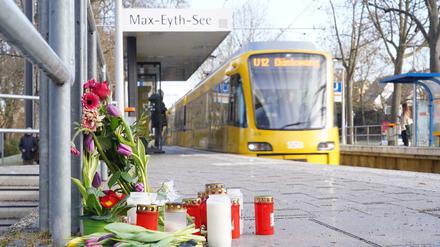 Blumen und Kerzen stehen an der Haltestelle «Max-Eyth-See» in Stuttgart.