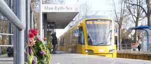 Blumen und Kerzen stehen an der Haltestelle «Max-Eyth-See» in Stuttgart.