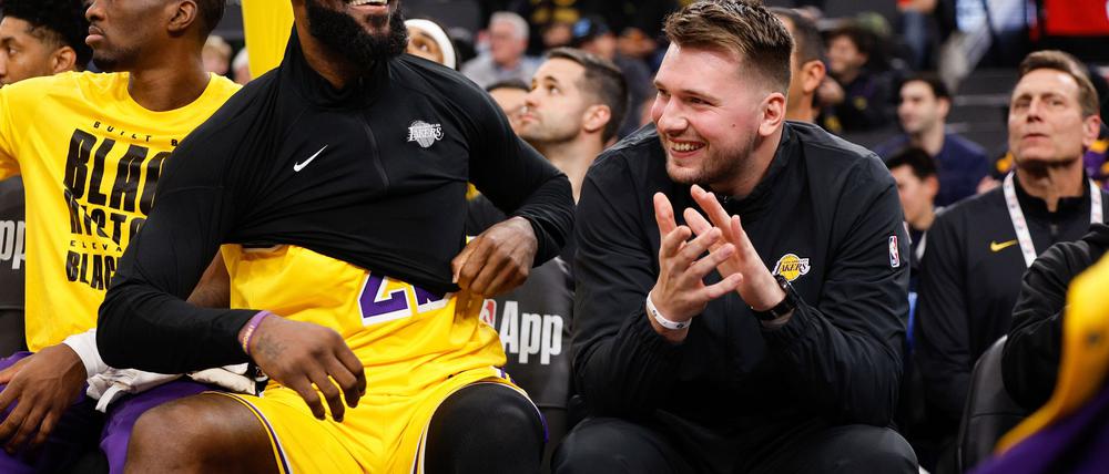 Luka Doncic (r.) verfolgte das Spiel als Zuschauer, hier neben LeBron James.