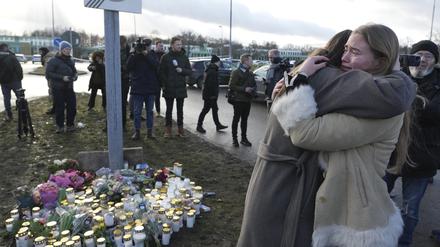 In der Nähe des Tatorts gedenken Menschen mit Blumen und Kerzen der Todesopfer in Örebro.