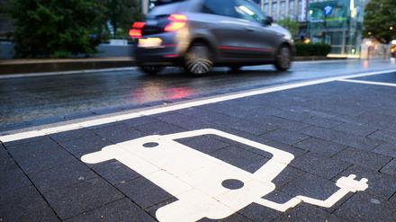Ein Symbol markiert einen Parkplatz an einer Ladesäule für Elektroautos. 