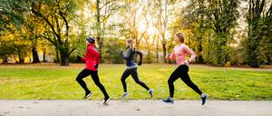 Drei Läuferinnen in einem Park.