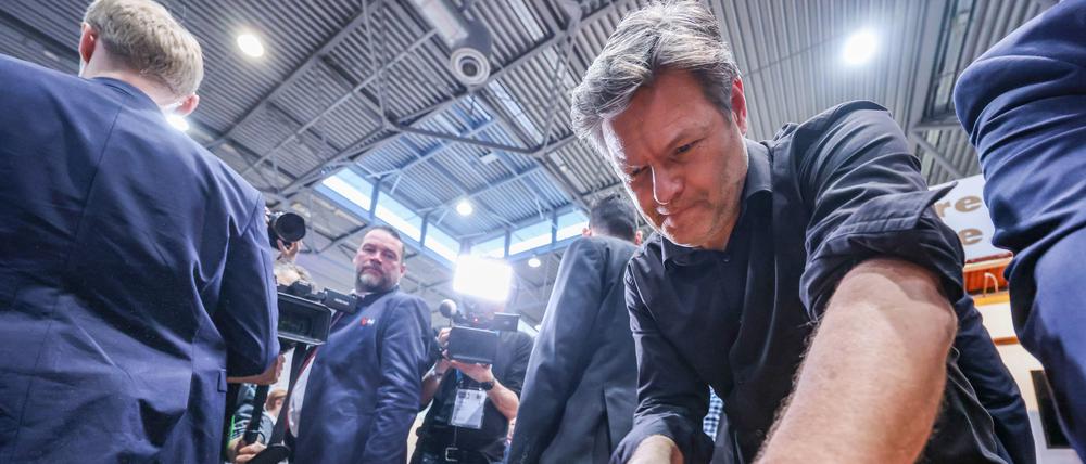 Robert Habeck (Bündnis 90/Die Grünen), Bundesminister für Wirtschaft und Klimaschutz, sägt am Stand einer Tischlerei auf der Mitteldeutschem Handwerkermesse.