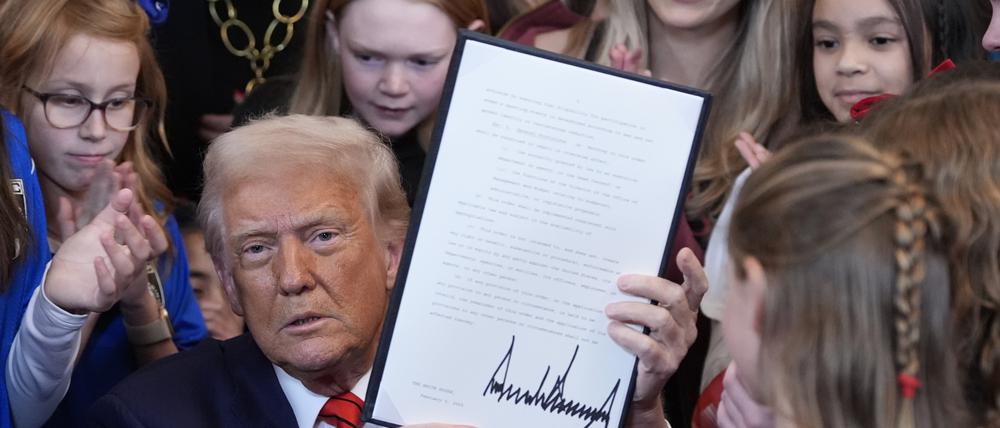 US-Präsident Donald Trump zeigt eine unterzeichnete Anordnung, die Transmenschen von der Teilnahme am Frauensport ausschließen soll.