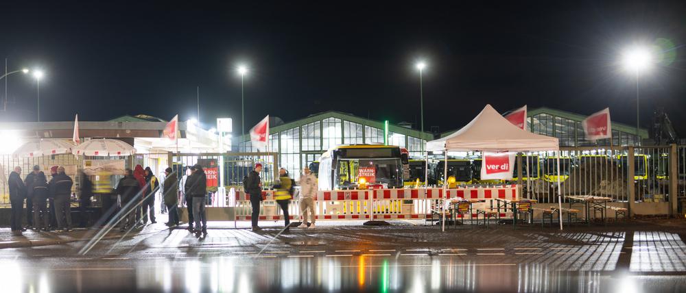 Streikende stehen während des Verdi-Warnstreiks bei der BVG vor einem Betriebshof in der Müllerstraße. 