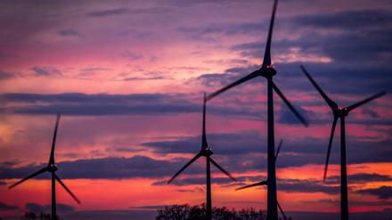Die Rotoren von Windkraftanlagen drehen sich nach Sonnenuntergang in einem Windpark. 