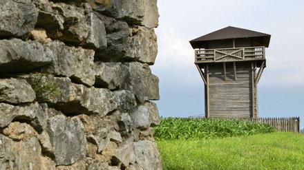 Hinter einer alten Mauer ist in der Nähe von Weißenburg der Nachbau eines Limes-Wachturms zu sehen.