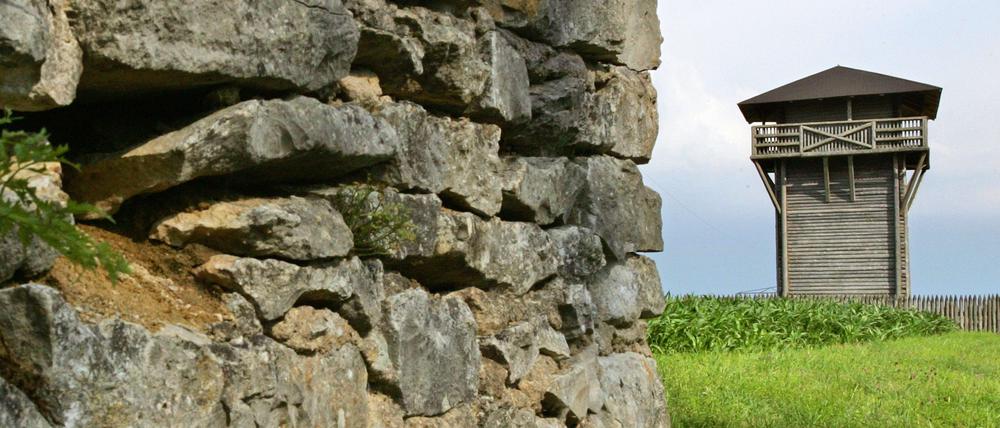 Hinter einer alten Mauer ist in der Nähe von Weißenburg der Nachbau eines Limes-Wachturms zu sehen.
