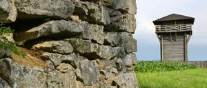 Hinter einer alten Mauer ist in der Nähe von Weißenburg der Nachbau eines Limes-Wachturms zu sehen.