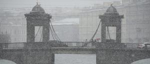 Ein Boot fährt bei Schneefall auf dem Fluss Fontanka in St. Petersburg, Russland.